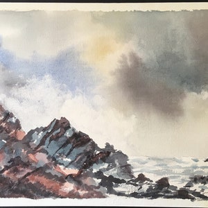 May include: A watercolor painting of a rocky coastline with crashing waves and a cloudy sky. The sky is a mix of gray, blue, and white, with a hint of yellow in the center. The rocks are a dark gray and brown, with some areas of white foam from the waves.