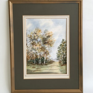 May include: A framed watercolor painting of a path through a forest with trees in autumn colors. The trees are mostly yellow and green with a few brown branches. The path is lined with trees on both sides and leads to a clearing in the distance. The painting is signed "D. Balmer" in the lower right corner.