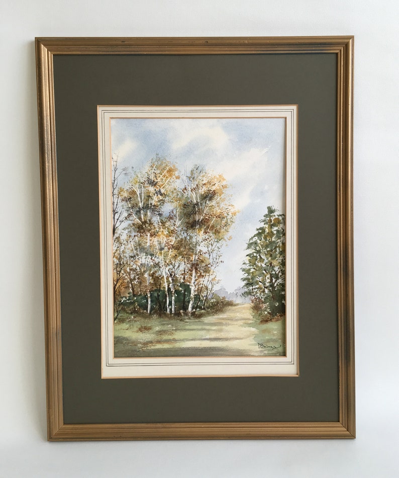 May include: A framed watercolor painting of a path through a forest with trees in autumn colors. The trees are mostly yellow and green with a few brown branches. The path is lined with trees on both sides and leads to a clearing in the distance. The painting is signed "D. Balmer" in the lower right corner.