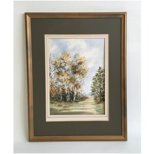 May include: Framed watercolor painting of a forest scene with a path leading through the trees. The trees are a mix of green and yellow, and the sky is a light blue with white clouds.