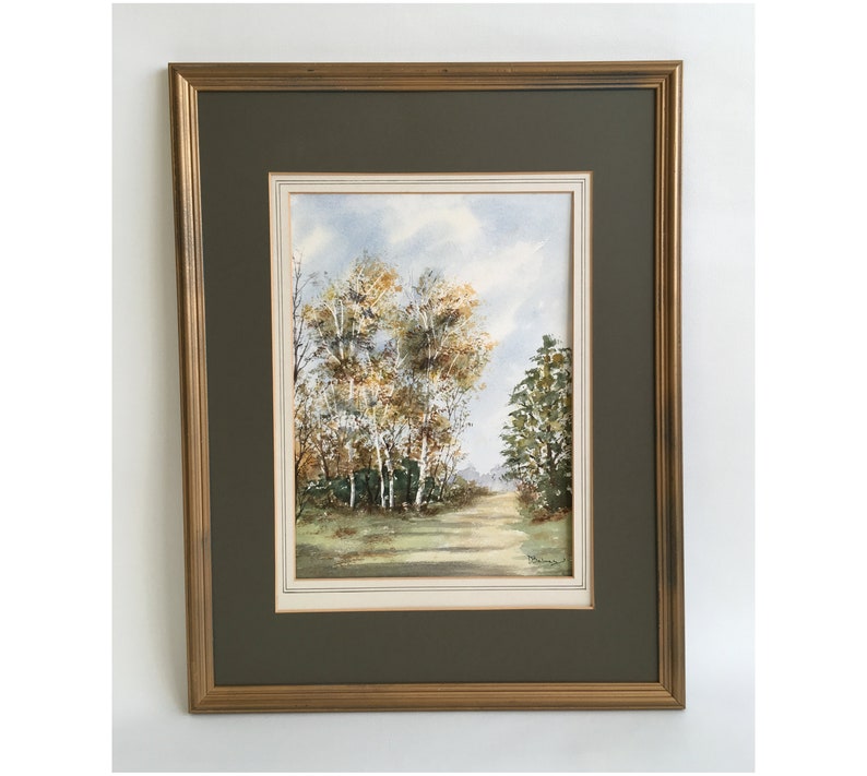 May include: Framed watercolor painting of a forest scene with a path leading through the trees. The trees are a mix of green and yellow, and the sky is a light blue with white clouds.