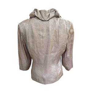 K&ouml;nnte beinhalten: Hellbeige Blazer mit strukturierter Oberfl&auml;che. Die Jacke hat einen einzigartigen, drapierten Kragen und Dreiviertel&auml;rmel. Die R&uuml;ckansicht des Blazers vor wei&szlig;em Hintergrund.
