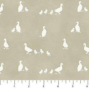 May include: Tan fabric with a repeating pattern of white duck silhouettes. The design includes adult ducks and ducklings, creating a family scene. The fabric has a subtle texture and is suitable for various sewing projects.