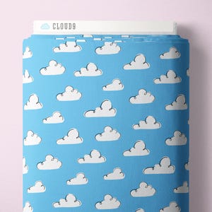 May include: A roll of blue fabric with a white cloud pattern. The fabric has a light blue background with numerous white, fluffy cloud illustrations. The text "CLOUD9" is visible on the top edge of the fabric roll.