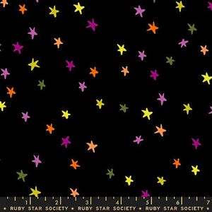 May include: A black fabric featuring a scattered pattern of hand-drawn style stars in yellow, orange, purple, and olive green. A black ruler at the bottom shows measurements from 0 to 18 cm, with the text RUBY STAR SOCIETY printed repeatedly.