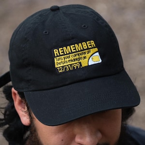 以下が含まれることがあります： 「REMEMBER turn your computer off before midnight on 12/31/99.」と書いてある黄色いパッチが付いた黒い野球帽