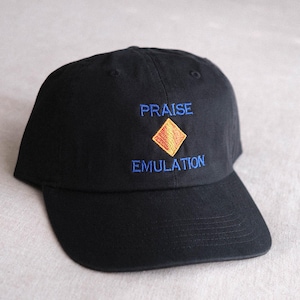May include: A black baseball cap featuring embroidered text that reads PRAISE above and EMULATION below a central orange diamond shape. The cap has a curved brim and a structured crown with stitched eyelets on the top panels of the fabric.