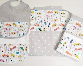 May include: A set of baby bibs and burp cloths with a white background and a colorful pattern of cars and trucks on a gray road. The bibs and burp cloths are made of soft, absorbent fabric and are perfect for keeping baby clean and dry.