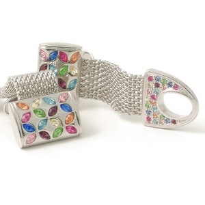 May include: Silver cufflinks with a chain connector. The cufflinks are decorated with a colorful mosaic of small gemstones.