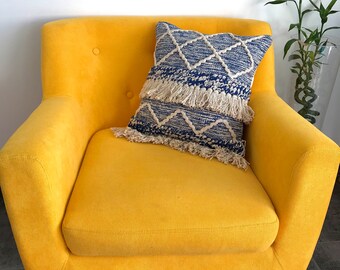 Blue macramé cushion cover in pure unbleached cotton, with pompoms.