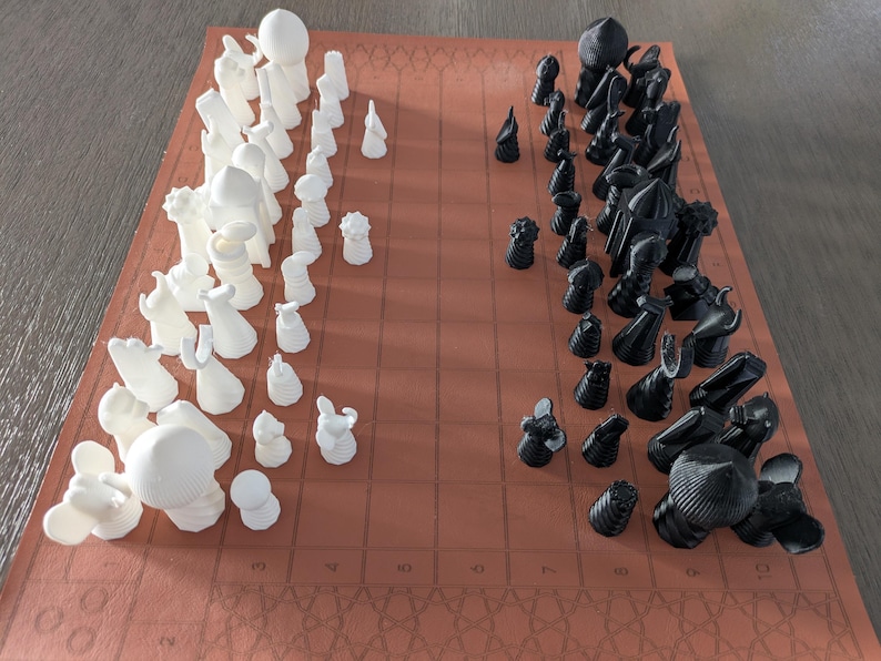 A Full Tamerlane (also known as Tamerlane Chess Completed) set in starting array on a 10x11 board with citadel squares on the 2nd and 8th ranks. This variant features several additional pieces over standard Tamerlane Chess including the bull, the lion, the revealer or explorer, and the sea monster which replaces the vizier.