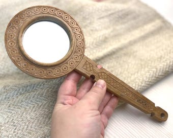 Espejo de mano vintage de madera con intrincados tallados, diseño de arte tradicional.