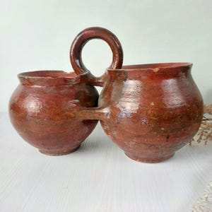 Puede incluir: Juego de tres tazas de cerámica con acabado mate moteado. Las tazas son de color crema, gris claro y gris oscuro. Cada taza tiene un diseño minimalista y un asa redondeada.