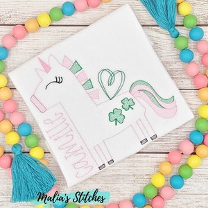 May include: White embroidered shirt with a pink and green unicorn design. The unicorn has a heart and shamrocks. The text "Goin' to the" is embroidered on the shirt.