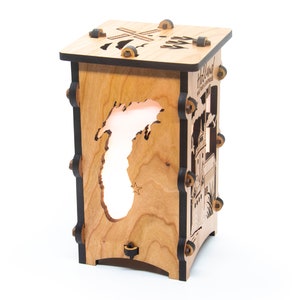 Puede incluir: Una l&aacute;mpara de madera con un recorte del estado de Michigan y el texto "Holland, The City of Windmills" en el lateral. La l&aacute;mpara est&aacute; iluminada desde el interior, proyectando un c&aacute;lido resplandor.