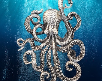May include: A detailed silver-colored octopus pendant with textured skin and curled tentacles. The pendant is set against a blue background with bubbles, creating an underwater scene. The octopus design is intricate and eye-catching.