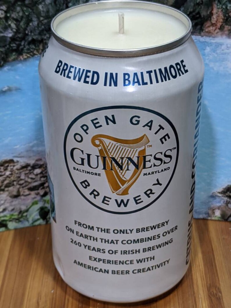 May include: A white candle in a Guinness Brewery beer can. The can features the brewery's logo and text that reads "BREWED IN BALTIMORE" and "FROM THE ONLY BREWERY ON EARTH THAT COMBINES OVER 260 YEARS OF IRISH BREWING EXPERIENCE WITH AMERICAN BEER CREATIVITY."