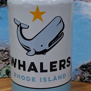 May include: A white beer can with a blue whale illustration and a yellow star. The can reads "Whalers Rhode Island" and "American Pale Ale". The can has a light blue band at the bottom.