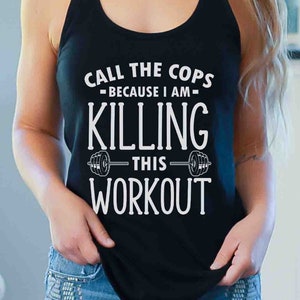 Puede incluir: Un top negro de tirantes con un gráfico blanco que dice "Call the Cops - Because I am - Killing This Workout" con un gráfico de mancuerna a cada lado del texto.