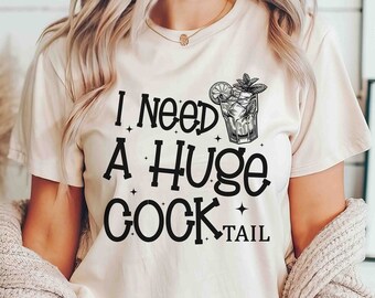 May include: A white t-shirt with a black graphic that says "I need a huge cocktail" and a drawing of a cocktail glass with a lemon and mint.