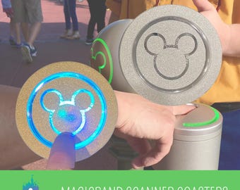 Könnte beinhalten: Ein runder, goldfarbener Untersetzer mit einer zentralen Mickey-Maus-Kontur, die von einem hellblauen Licht beleuchtet wird. Die Oberfläche hat ein strukturiertes, glitzerndes Finish. Ein zweiter silberner Untersetzer mit Mickey-Maus-Symbol ist sichtbar.