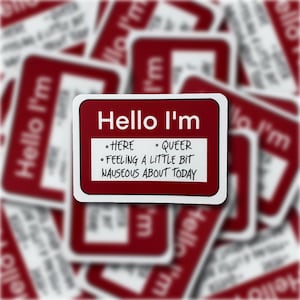 May include: Red and white sticker with the text "Hello I'm" and a list of bullet points: "Here", "Queer", "Feeling a little bit nauseous about today".