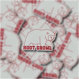May include: A white sticker with a red outline of a bear walking and the text "HOOT GROWL" in red.