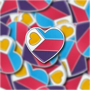 May include: A sticker of a heart with a multi-colored design. The heart is divided into four sections: blue, pink, purple, and a small yellow heart in the top left corner. The sticker is surrounded by other heart stickers in various colors.