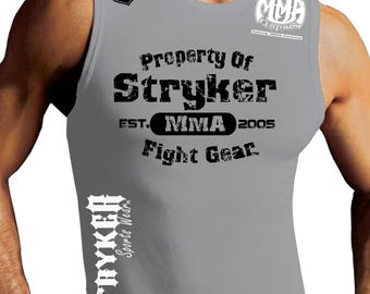 Puede incluir: Camiseta gris sin mangas con un estampado gráfico negro que dice "Property of Stryker EST. MMA 2005 Fight Gear" con un logotipo más pequeño que dice "MMA Customs" en la esquina superior derecha.