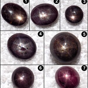Könnte beinhalten: Sieben polierte Sternrubin-Edelsteine in verschiedenen Formen. Die Edelsteine, von oval bis rund, weisen einen Sterneneffekt auf ihren Oberflächen auf. Die Farben reichen von tiefem Burgunderrot bis fast Schwarz, mit schimmernder, reflektierender Qualität.