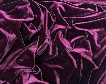 May include: A deep purple velvet fabric with a soft, plush texture. The fabric is draped and folded, showcasing its luxurious feel.