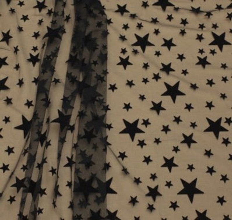 May include: Black sheer fabric with a pattern of black velvet stars of different sizes.