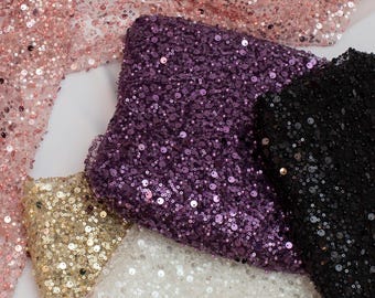 Puede incluir: Cuatro telas de lentejuelas de diferentes colores, incluyendo dorado, morado, negro y rosa. La tela está hecha de un material de malla con lentejuelas cosidas.