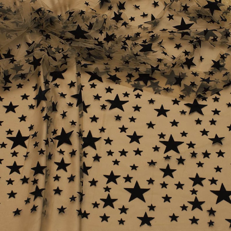 May include: Beige sheer fabric with a black velvet star pattern. The stars are of varying sizes and are scattered randomly across the fabric.
