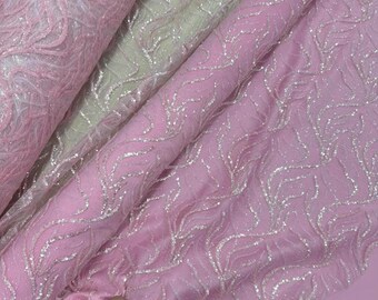 May include: Close-up of several layers of pink fabric with a shimmering, silver leaf-like pattern. The fabric is soft and appears to be draped, with varying shades of pink and a hint of white.