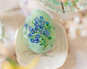 Decorative ceramic egg, Easter ornament with hand-painted flowers, spring floral decoration made of spun cotton.