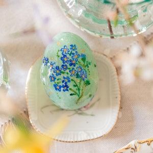 Decorative ceramic egg, Easter ornament with hand-painted flowers, spring floral decoration made of spun cotton.