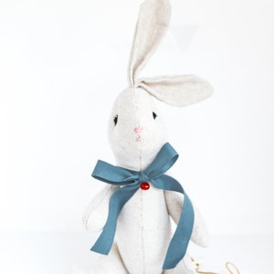 peluche en forme de lapin avec noeud bleu et clochette rouge. Sur commande. image 2