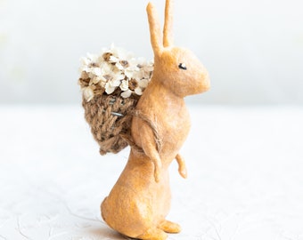 Rabbit with basket of flowers, decorative hare in cotton wool, collectible figurine in spun cotton