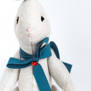peluche en forme de lapin avec noeud bleu et clochette rouge. Sur commande. image 3