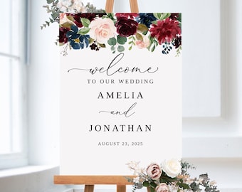 Könnte beinhalten: Ein weißes Hochzeitsschild mit einem floralen Rand in den Farben Burgunderrot, Rosa und Blau. Das Schild lautet "Willkommen zu unserer Hochzeit Amelia und Jonathan 23. August 2025".