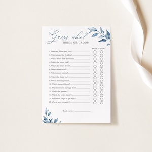 以下が含まれることがあります： 結婚式の前夜祭やブライダルパーティー用の印刷可能な「誰が誰？」ゲーム。ゲームには、青い水彩画の花柄が描かれており、花嫁と新郎について、誰がより辛抱強いのか、誰が料理が得意なのかなど、質問が書かれています。