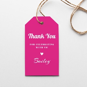 May include: Pink thank you tag with white text that reads "Thank You for celebrating with us! Bailey". A small white heart is above the name Bailey.