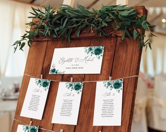 May include: A wooden board with a string of twine holding cards with guest names and table numbers. The cards have a teal floral design and the text "Elizabeth & Michael" is at the top of the board.
