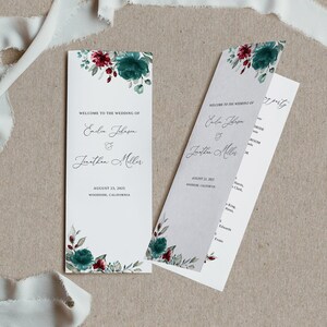 May include: Wedding program with a floral design featuring teal and burgundy flowers. The program includes the names of the couple, Emelia Johnson and Jonathan Miller, the wedding date, August 23, 2025, and the location, Woodside, California.