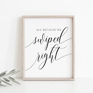 May include: A white framed print with black calligraphy that reads "All because we swiped right".