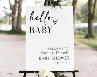 Pode incluir: Um cartaz de boas-vindas branco com texto preto que diz "hello baby" com um pequeno símbolo de coração. O cartaz também diz "Bem-vindos ao Chuveiro de Bebê de Sarah & Daniel 16 de agosto de 2025". O cartaz está em um cavalete preto.