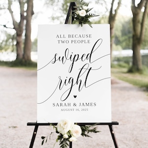 May include: White wedding sign with black calligraphy that reads "All because two people swiped right. Sarah & James August 16, 2025".