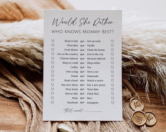May include: A white card with the text "Would She Rather" and "Who Knows Mommy Best?"  The card has a list of 14 questions with two choices for each question.  The choices are separated by the word "or".  The card has a line at the bottom for "Total Correct".