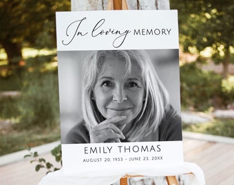 May include: Black and white photo memorial sign with the text "In loving memory" at the top, a photo of a woman in the middle, and the text "Emily Thomas, August 20, 1953 - June 23, 20XX" at the bottom.